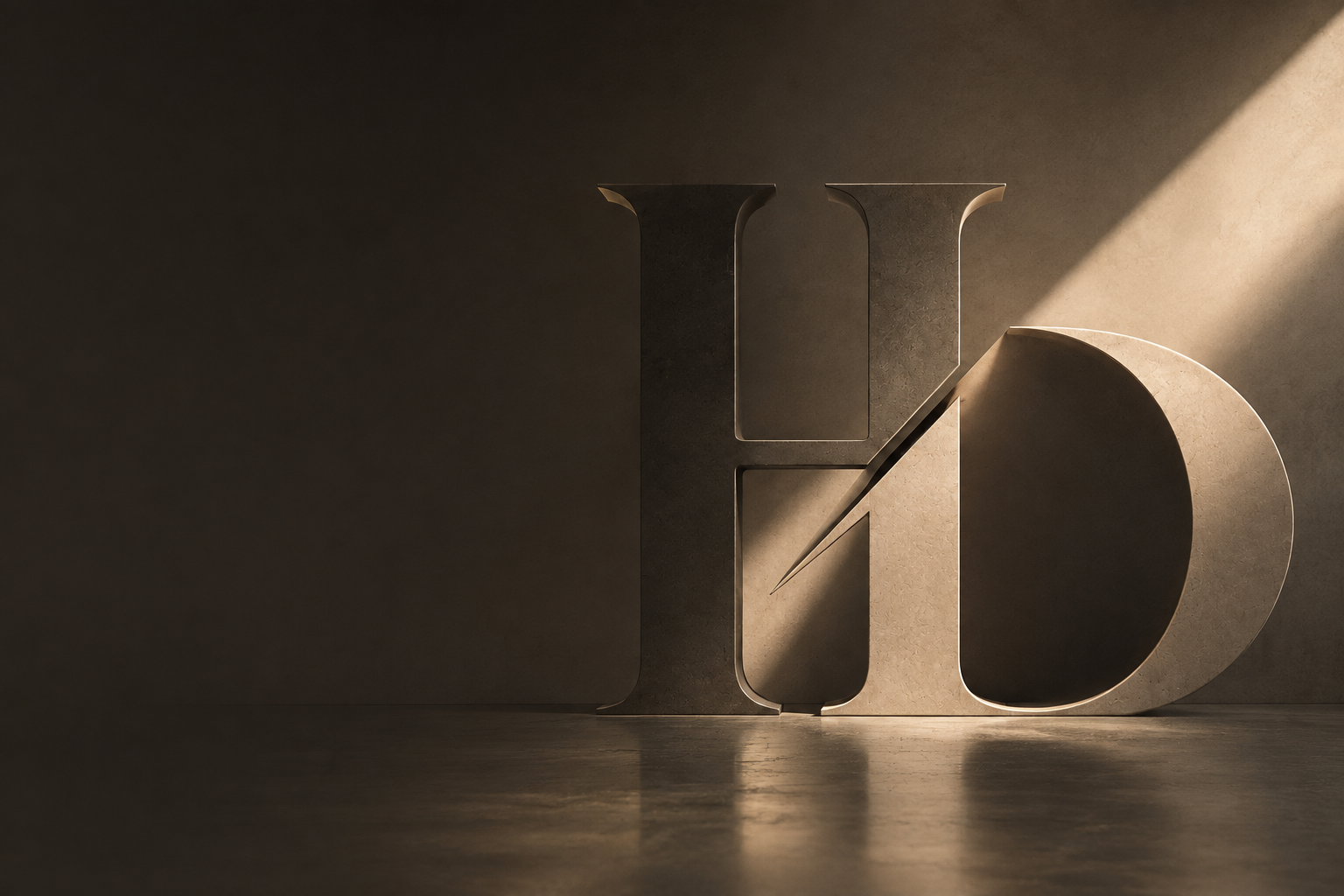 A sculpted stone HoD monogram lit by a single diagonal shaft of light in a dark studio.